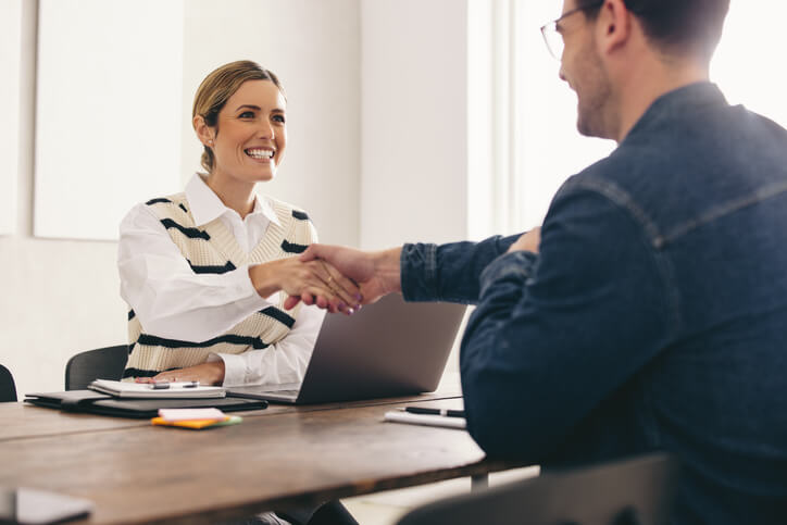 A smiling HR manager with a new employee after business administration training